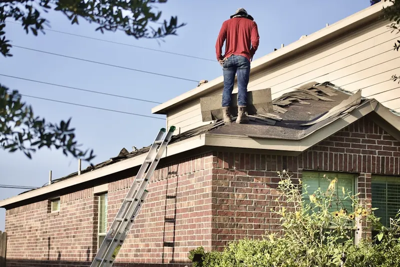 Professional roofer working on a residential roof in Elliot